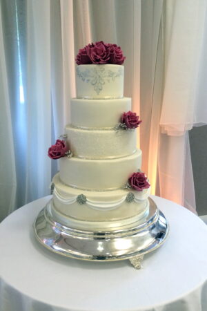Stencilled lace, swags & diamante embellishments with burgundy sugar roses