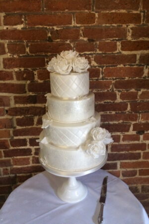 White roses and delicate butterflies on pearlised four tier cakee