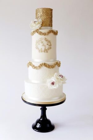 Gold swag cake with gold stencilled monogram, sequins & blush sugar roses. www.gillflettlifestyle.com